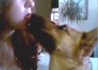Good-looking lady puts her tongue in dog's mouth