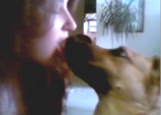 Good-looking lady puts her tongue in dog's mouth